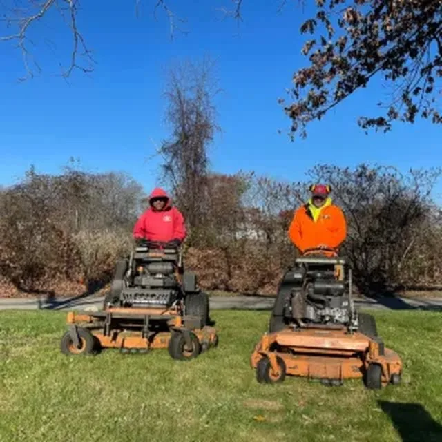 Crew mowing a lawn on stand-on mowers